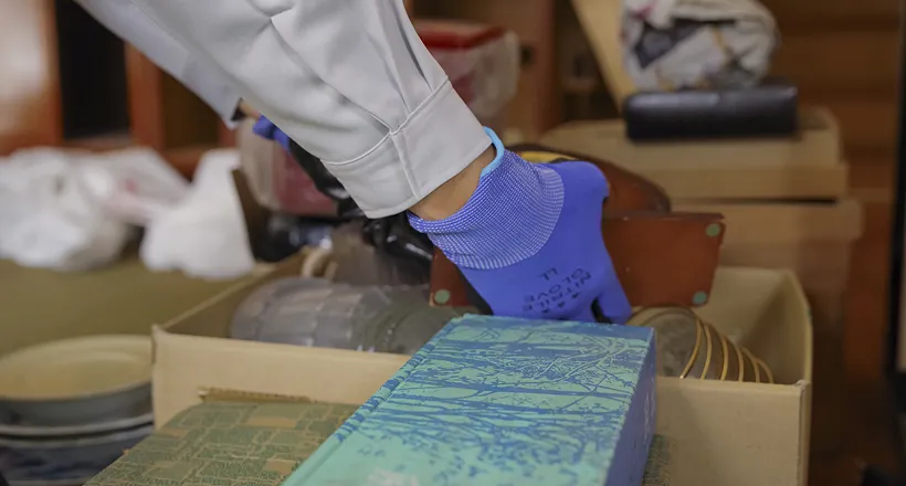 作業員が本やアルバムなどを整理している場面