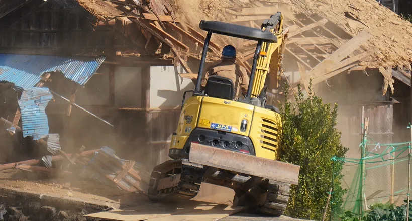 重機が古い建物を解体している現場